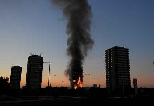 Cột khói đen bốc lên từ tháp Grenfell sáng sớm 14/6. Ảnh: Reuters.