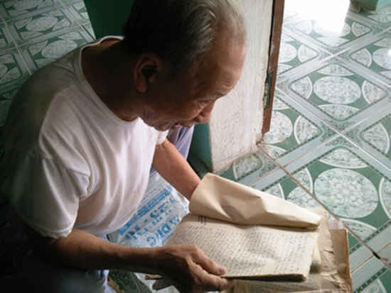 Ông Châu đọc lại hồ sơ các vụ án mà mình đã tham gia xét xử - ảnh Thái Bá