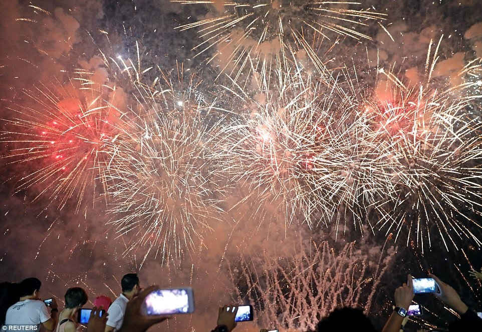 Hàng chục người tập trung tại một công viên giải trí ở Pasay, Manila để chụp ảnh pháo hoa chiếu sáng bầu trời đêm khi Philippines nhập vào năm 2018