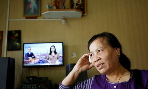 Bà Vy nhận điện thoại trong nhà riêng ở Nam Định hôm 1/4, sau khi biết tin con gái Đoàn Thị Hương thoát án tử hình. Ảnh: Reuters.