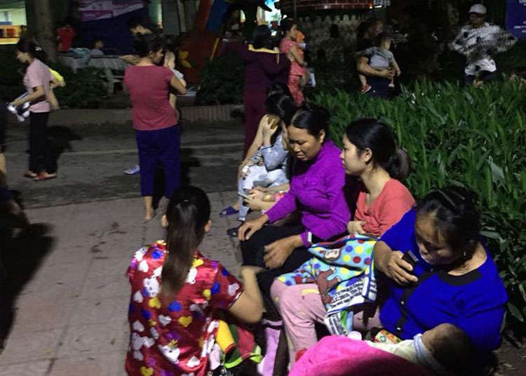 Hàng chục người nhà bế theo bệnh nhi ở các tầng xuống dưới sân toà nhà.Ảnh:Mai Hương