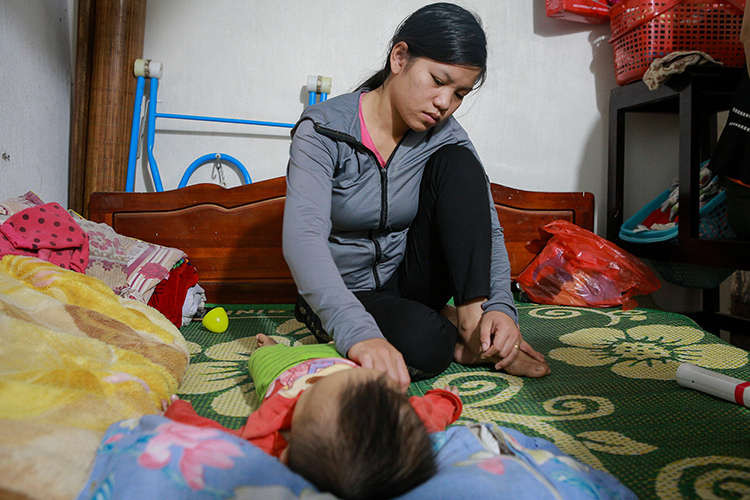 Chị Thái Thị Giang (huyện Diễn Châu, Nghệ An) bên con trai 11 tháng tuổi, vừa ngóng tin chồng – anh Cao Huy Thành mất tích tại Anh. Ảnh: Nguyễn Hải.