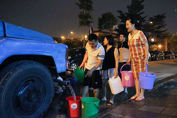 Người dân xếp hàng hứng nước đêm như thời bao cấp ở Hà Nội hồi tháng 10. Ảnh: Giang Huy.